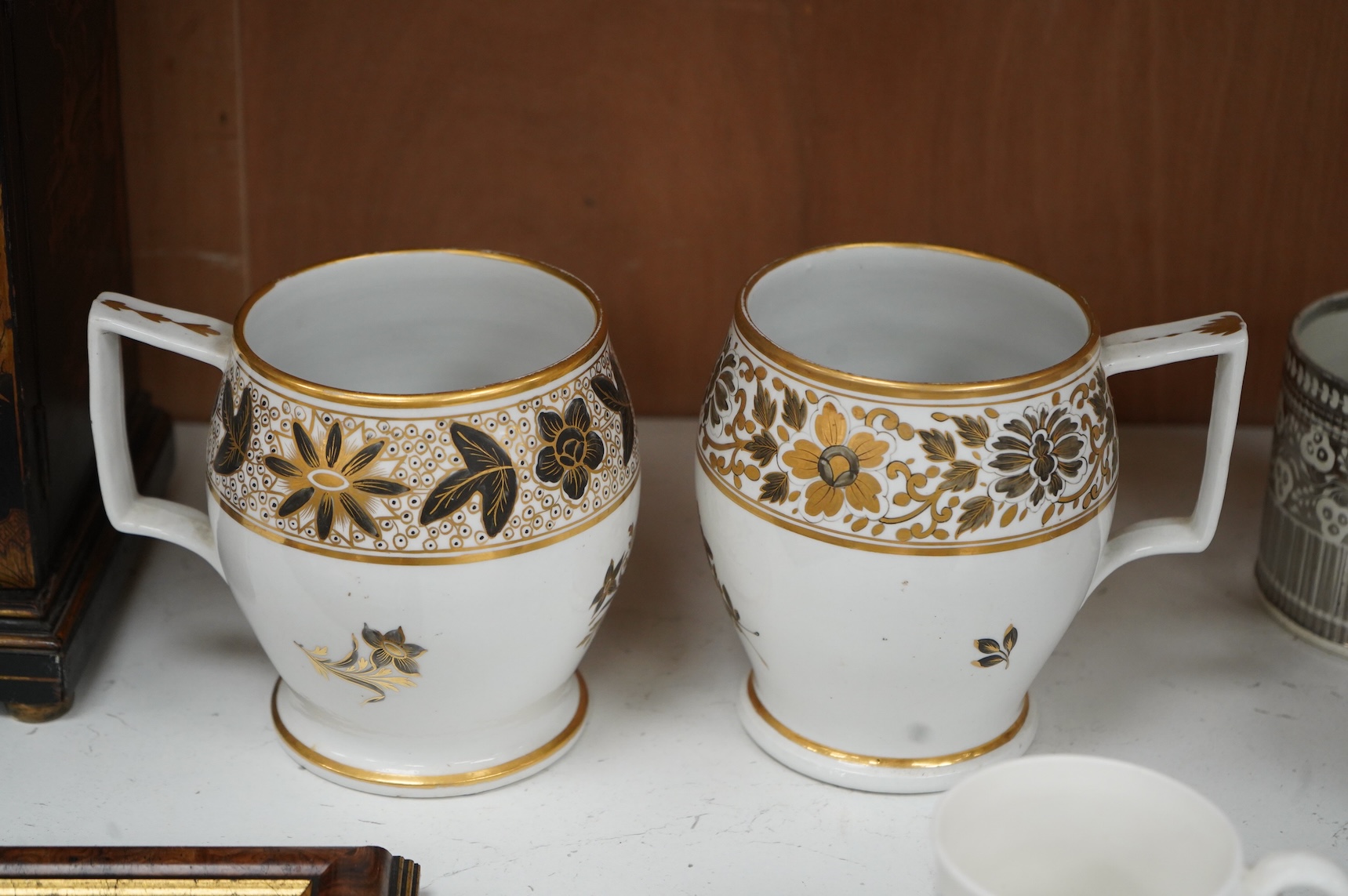 A pair of early 19th century English porcelain large mugs with gilt bands and five other early 19th century porcelain or pearlware mugs, one inscribed SG, Forget Me Not, largest each 14cm high